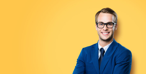 Portrait of businessman in eye glasses, spectacles, suit and tie, isolated against vivid yellow...