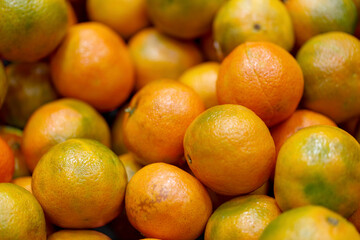 Tangerine texture background photo, Defocused. Pile of fresh tangerines, juicy citrus on the counter at the local market. Christmas, close up frame oranges, as a symbol of good luck, New Year mood