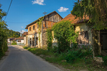 Derelict houses on the edge of Kulen Vakuf Village in the Una National Park. Una-Sana Canton, Federation of Bosnia and Herzegovina. The minaret of Sultan Ahmedova Dzamija or Sultan Ahmed Mosque is in 