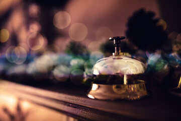reception bell on the table and color shining garland on background - obrazy, fototapety, plakaty