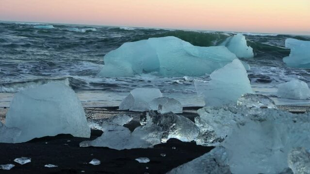 Icebergs and ice blocks on the black sand on the shore in Iceland.