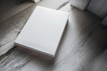 hardcover books with blank cover isolated on a wooden table - obrazy, fototapety, plakaty