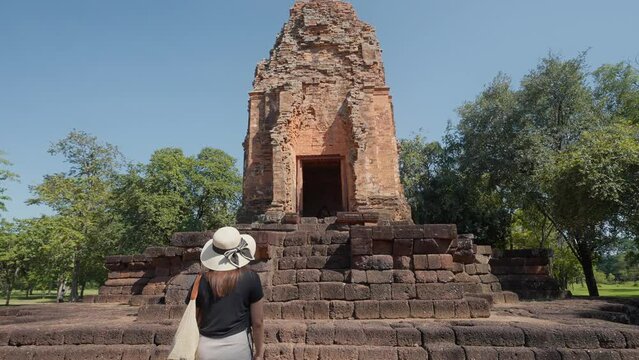 Back view of female tourists walking into ancient architecture at Si Thep historical park new world heritage site in Phetchabun, Thailand. New UNESCO archaeological site in Petchabun Thailand