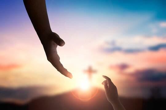 God's helping hand and cross on sunset background
