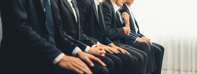 Group of interviewee candidate in formal suit line up for interview sitting on the chair. Job...
