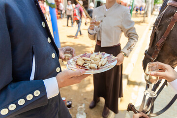 Crop anonymous elegant people drinking wine and eating appetizers during festival