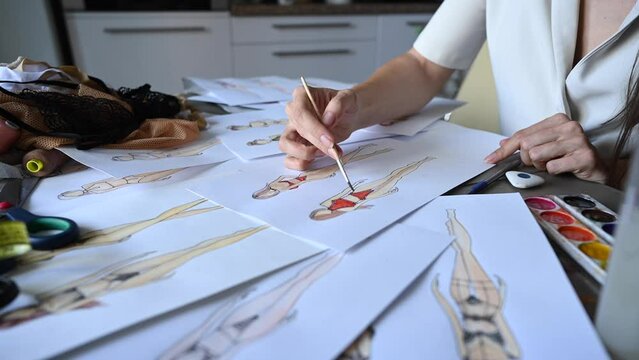 Faceless woman sketches swimwear and underwear. Close-up of fashion designer's hands.