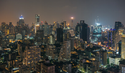 Fototapeta na wymiar Night urban Bangkok cityscape skyline panorama of modern illuminated city with glowing skyscrapers and buildings in dusk. High-angle view on metropolis lights in twilight