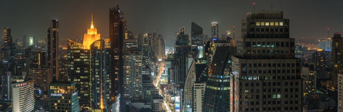 Bangkok night cityscape skyline panorama of modern city with glowing skyscrapers and illuminated buildings in dusk. High angle view urban landscape