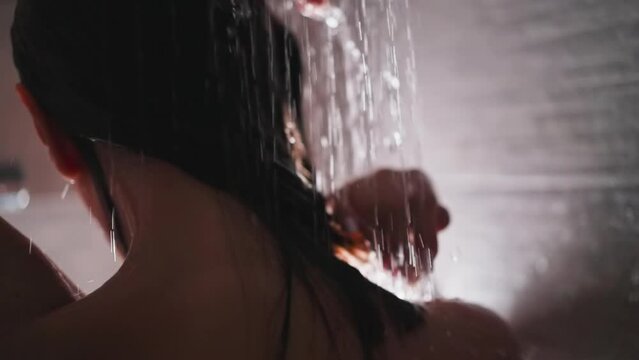 Woman enjoys hair washing in shower unit