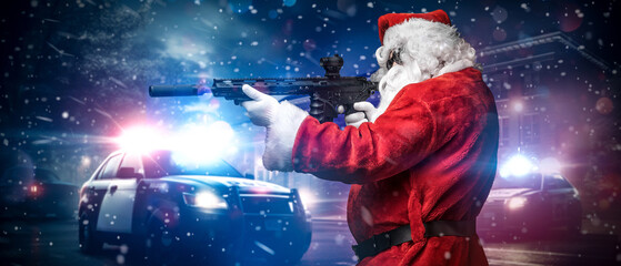 A man dressed as Santa Claus, aiming with a machine gun, poses in front of police cars with...