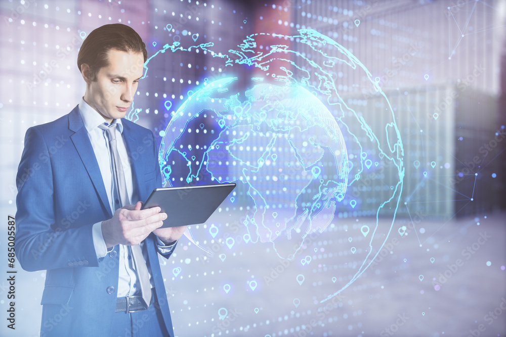Poster young european businessman using tablet with glowing globe hologram with location pins on blurry off