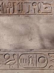 Vertical background with ancient Egyptian hieroglyphs on stone wall, Egypt, Africa. Backdrop with...