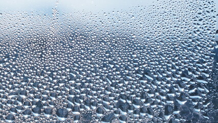 Condensation on window glass in frosty winter weather. Background in the form of small drops on the glass.