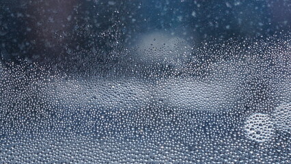 Obraz premium Condensation on window glass in frosty winter weather. Background in the form of small drops on the glass.