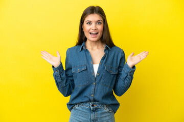 Young caucasian woman isolated on yellow background with shocked facial expression