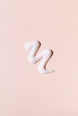 cosmetic smears of creamy texture on a pastel beige background