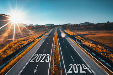 Driving on open road at beautiful sunny day to new year 2024. Aerial view - obrazy, fototapety, plakaty