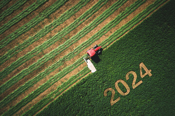 2024 Happy Ney Wear concept and red tractor mowing green field