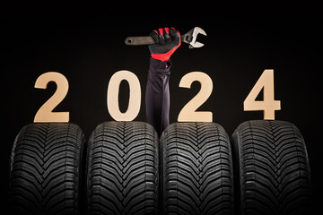 Winter car tires service and thumbs up hands of mechanic and text 2024 happy new year on black background - 685009555