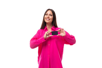 smiling caucasian woman with black straight hair dressed in crimson shirt holding a plastic card mockup