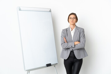 Young Ireland woman isolated on white background with arms crossed while giving a presentation on white board