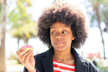 African American girl at outdoors holding a donut