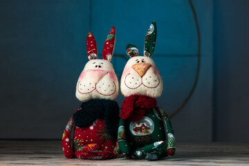 Two tilda New Year's hares handmade toys on a blue background