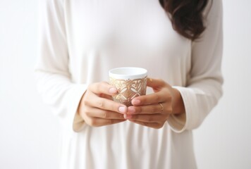 hands holding cup of coffee near the white background,