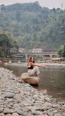 Vang Vieng river in Vietnam, girl sitting on a rock