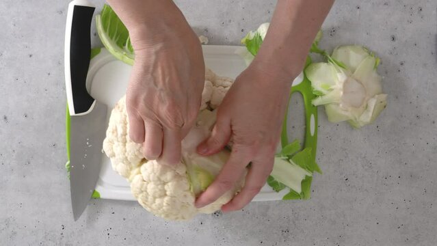 The chef devided cauliflower into florets, the cooking process, view from above. 