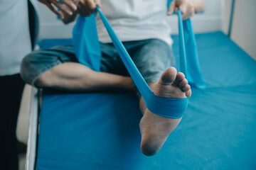 Doctor or physical therapist examines back pain and spinal area to give advice within the rehabilitation center.