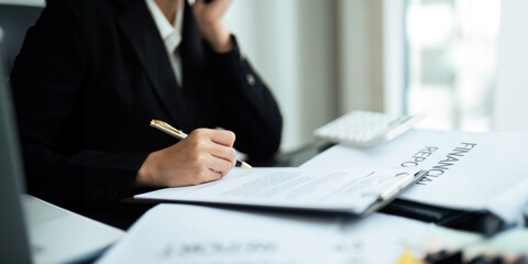 Businesswoman accountant using calculator and laptop for financial data saving in office room, Business financial, tax, accounting concept