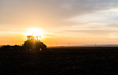 Fototapeta premium Farmer preparing his field in a tractor