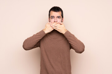 Man over isolated background covering mouth with hands