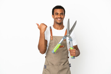 African American gardener man holding pruning shears over isolated white background pointing to the...