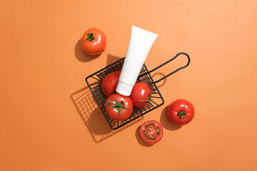 A basket containing fresh tomatoes with an unlabeled placed on top. Orange background. The Vitamin...