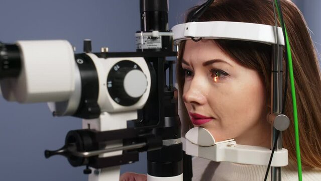 Eye examination and optometry to test your vision, medical consultation or glaucoma screening. Happy client with laser technology or eye scanning and ophthalmic test machine