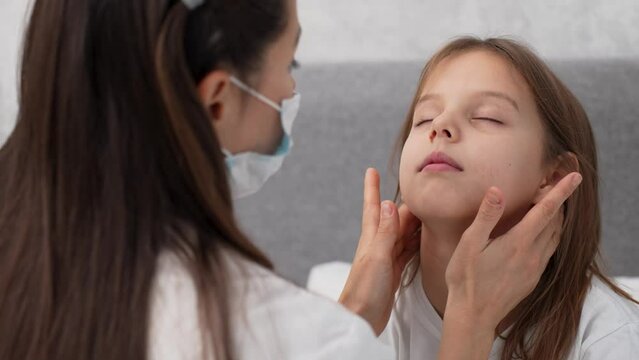 Pediatric doctor checking tonsils of a child girl