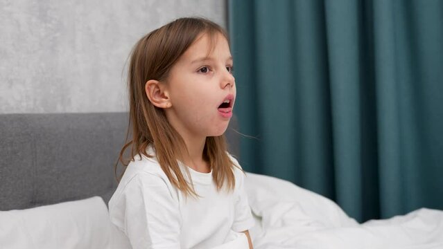 Child girl coughing, having sore throat