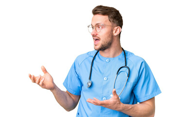 Young nurse man over isolated chroma key background with surprise facial expression