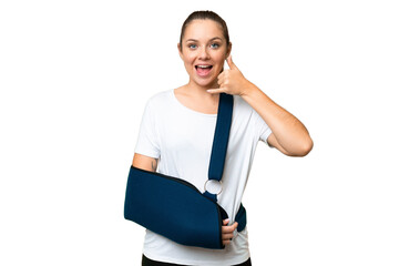 Young blonde woman with broken arm and wearing a sling over isolated chroma key background making...