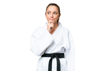 Young blonde woman doing karate over isolated chroma key background having doubts and thinking