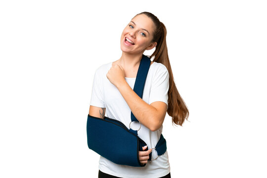 Young blonde woman with broken arm and wearing a sling over isolated chroma key background celebrating a victory