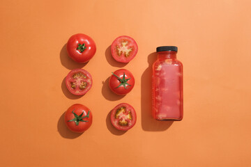 Tomatoes and slices of tomato arranged in two line with a bottle of tomato juice. Mockup design....