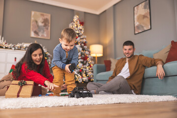Toddler learning to play with remote controlled car toy he got as Christmas present