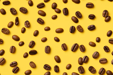 Pattern made of coffee beans against pastel yellow background, flat lay, minimalism