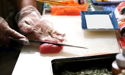 Chef use sharp knife slicing Tuna red fish for sashimi. Enjoy Omakase experience at Japanese Sushi...