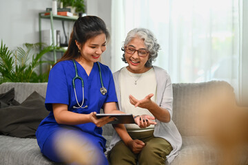 Obraz premium Female doctor showing positive test results to senior woman patient during home visit