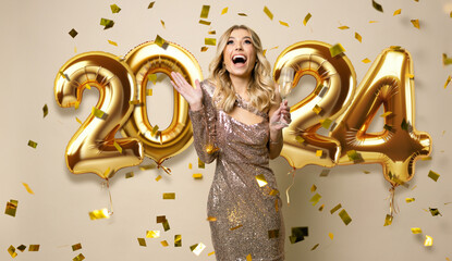 Happy New Year to you. Beautiful woman in sparkle dress standing under confetti rain with glass of...